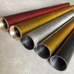 Red, blue, yellow and green carbon fiber tubes displayed in industrial setting